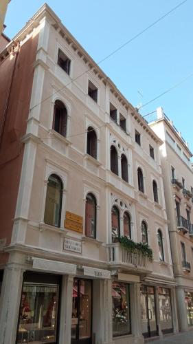 a large white building on the corner of a street at Ca' Pedrocchi in Venice