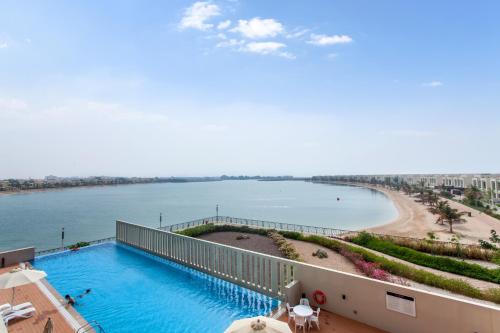 a view of the beach from the balcony of a building with a swimming pool at Live here, enjoy waters of Arabian Gulf in Ras al Khaimah