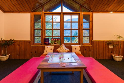 a room with a table and a large window at Zen Manali by Keekoo Stays in Manāli