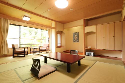 Joshinnosato Hibikino في Shibukawa: غرفة معيشة مع طاولة وكراسي ونافذة