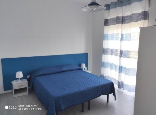 een slaapkamer met een blauw bed met een blauw hoofdeinde bij B&B Spirito Santo in Casal Sottano