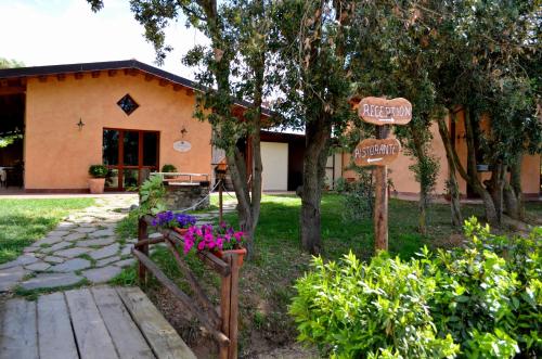 a house with signs and flowers in front of it at Tenuta Agricola dell'Uccellina in Talamone