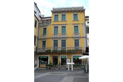un edificio amarillo al lado de una calle en Aparthotel All'Orologio, en Peschiera del Garda