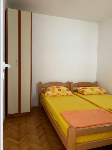 a bedroom with a bed with yellow sheets and pillows at Apartments Bojanic in Bar