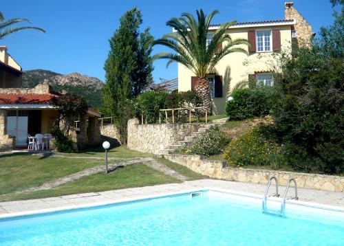 a large swimming pool in front of a house at Villa Casanova in Santa Margherita di Pula