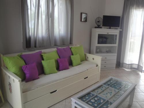 a living room with a couch with colorful pillows at Fiora Villas in Trapezaki