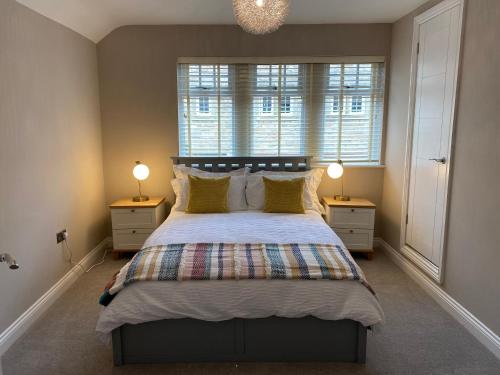 1 dormitorio con 1 cama grande y 2 mesitas de noche en No. 3 Tomlinsons Apartments, en Rothbury