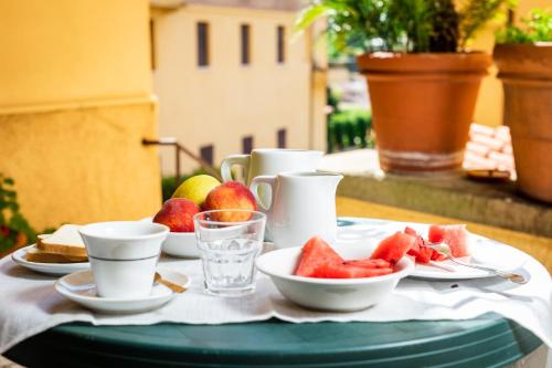 a table with plates of fruit and glasses of watermelon at Hotel Minerva in Siena