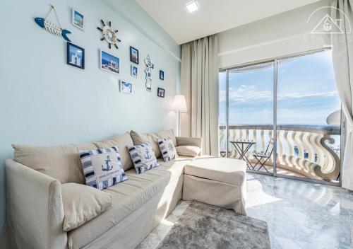 a living room with a couch and a large window at Port Dickson 10Pax 3BR Glory Beach Resort Seaview in Port Dickson