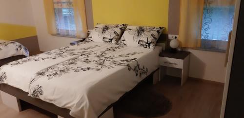 a bedroom with a bed with a white comforter at Apartments Vesna in Bled