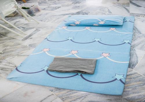 a blue bed with stars and a blanket on it at Port Dickson 10Pax 3BR Glory Beach Resort Seaview in Port Dickson