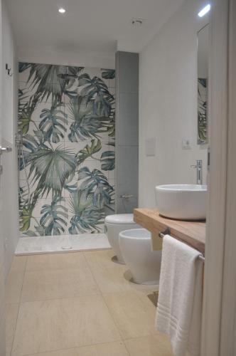 a bathroom with two sinks and two toilets and a shower at Clori in Pescia Romana