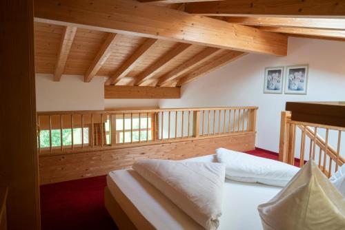 a bedroom with a white bed and wooden ceilings at Aparthotel Schindlhaus/Alpin in Söll