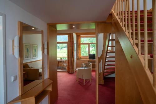a room with a staircase and a living room at Aparthotel Schindlhaus/Alpin in Söll