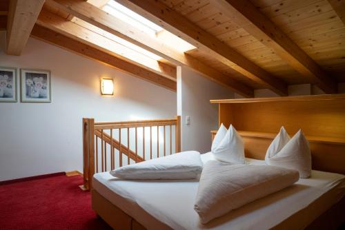 a bedroom with a bed with white pillows on it at Aparthotel Schindlhaus/Alpin in Söll