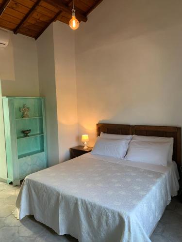 a bedroom with a bed with a white bedspread at Corte Boero Bed&Breakfast in Capoterra