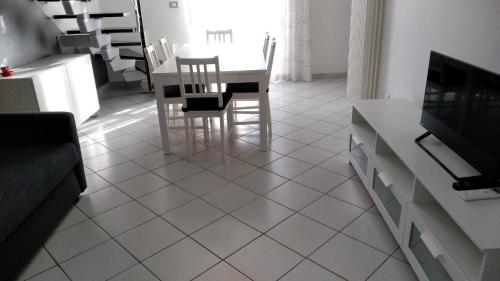 Il dispose d'une cuisine avec une table et des chaises. dans l'établissement Residenza Re Umberto, à Civitanova Marche