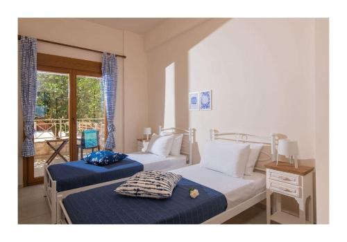 Duas camas num quarto com uma janela em Beachfront Blue apt-Ligaria beach em Ligaria
