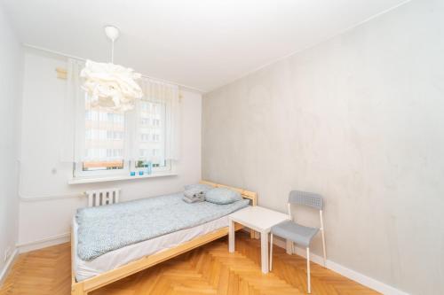 sypialnia z łóżkiem, krzesłem i oknem w obiekcie Redłowo Deluxe Cylkowskiego w mieście Gdynia