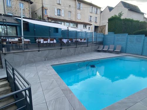 a swimming pool with chairs next to a building at Hotel Des Voyageurs in Le Rouget