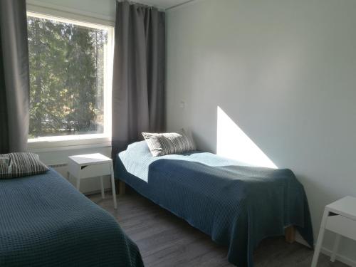 Un dormitorio con dos camas y una ventana. en Villa Repolainen, en Syöte