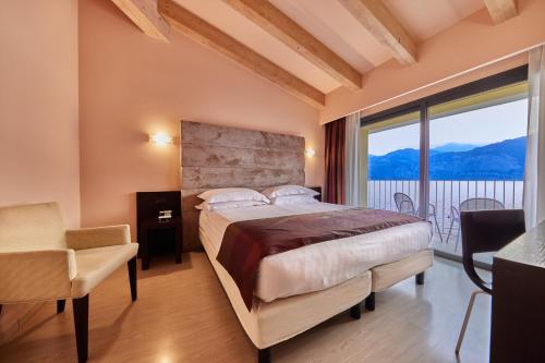 sypialnia z dużym łóżkiem i dużym oknem w obiekcie Hotel Europa w mieście Malcesine