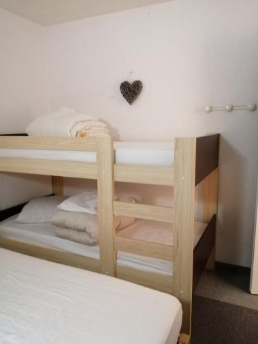 Cette chambre dispose de 2 lits superposés et d'un cœur sur le mur. dans l'établissement Soleil et Montagne Bâtiment E, aux Angles