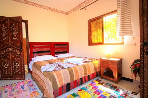 a bedroom with a bed and a table and a window at Jnane Karma in Imlil