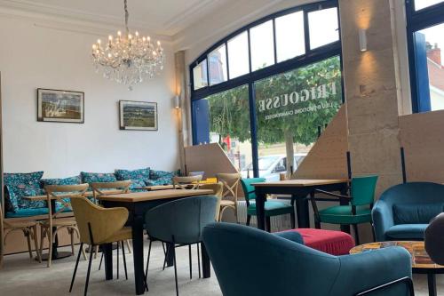 un restaurant avec des tables, des chaises et un lustre dans l'établissement Hyper centre Maison le petit Bouchon, à Ay