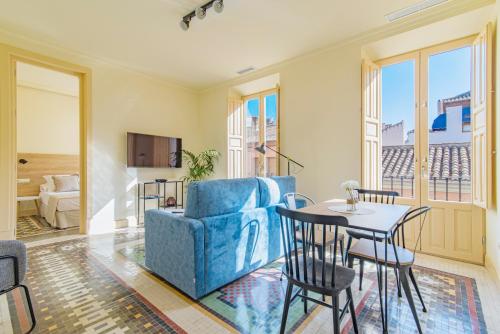a living room with a blue couch and a table at Mosaiko Homes Catedral Granada in Granada