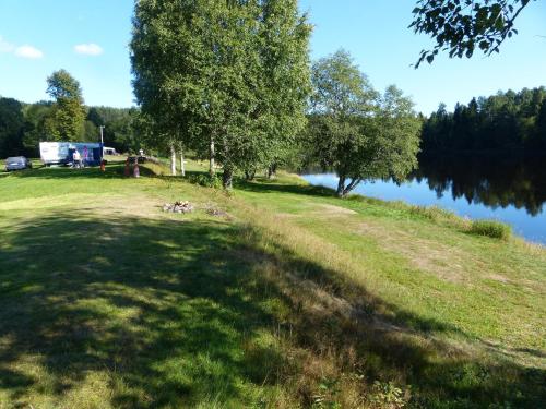 a grassy field next to a body of water at Björkebo Camping in Stöllet