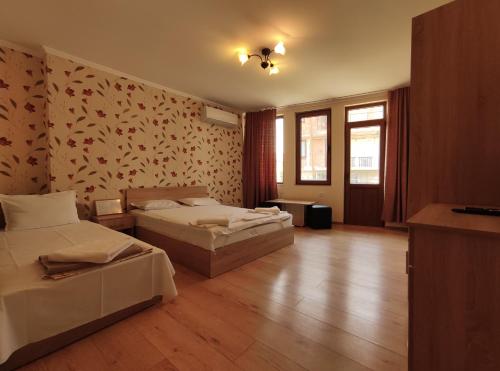 a bedroom with two beds and a wall with flowers at Family Hotel "Slavianska dusha" in Veliko Tŭrnovo