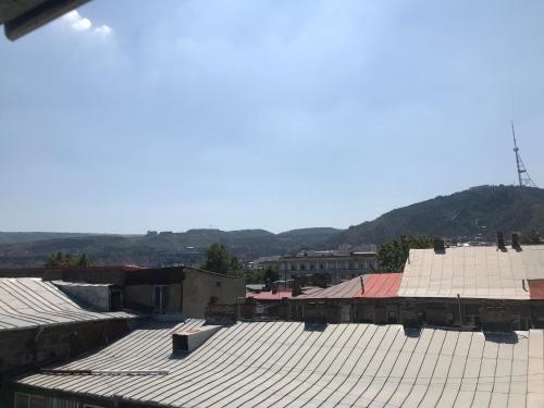 a view of roofs of buildings with mountains in the background at D and D hotel in Tbilisi City