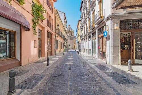 an empty street in a city with buildings at Mosaiko Homes Catedral Granada in Granada