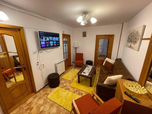 a living room with a couch and a flat screen tv at Like Home - Cozy & Quite in Piatra Neamţ