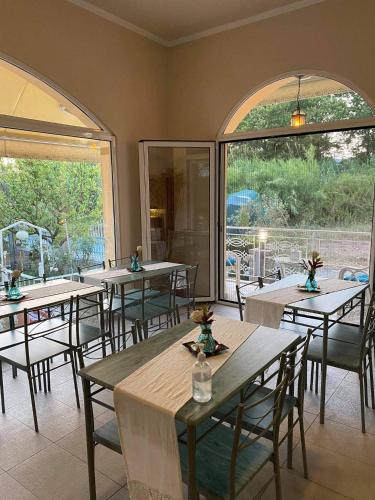 a restaurant with tables and chairs and large windows at Royal's Studios in Loutra Edipsou