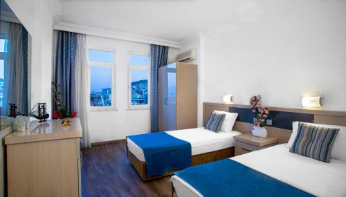 a hotel room with two beds and two windows at Angora Apart Hotel in Alanya