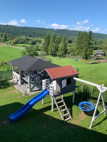 a playground with a slide and a play structure at Apartamenty Równia 2 in Ustrzyki Dolne