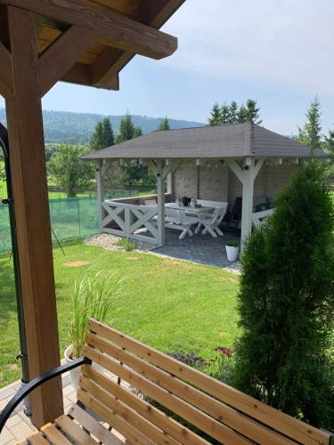 a wooden bench in front of a gazebo at Apartamenty Równia 2 in Ustrzyki Dolne