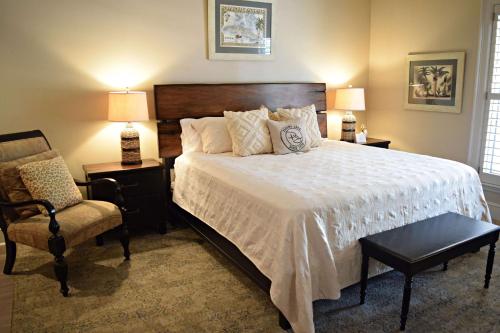 a bedroom with a large bed and a chair at JH Adams Inn, Trademark Collection by Wyndham in High Point