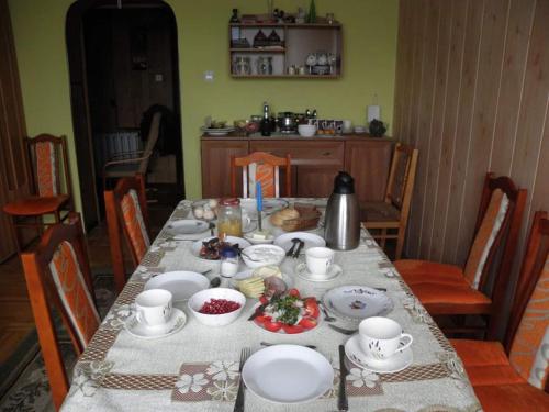 a dining room table with a table set with food at Siedlisko Pauza in Kozłów