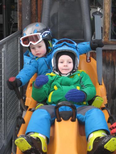 two young children are riding on a swing at Appartementhaus Charisma in Fieberbrunn