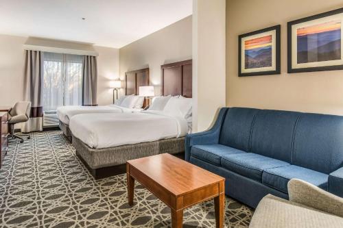 a hotel room with two beds and a couch at Comfort Inn & Suites Brevard North in Brevard