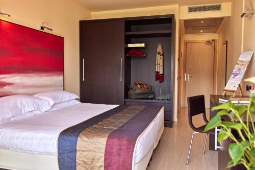a bedroom with a large bed with a red painting on the wall at Hotel Europa in Malcesine