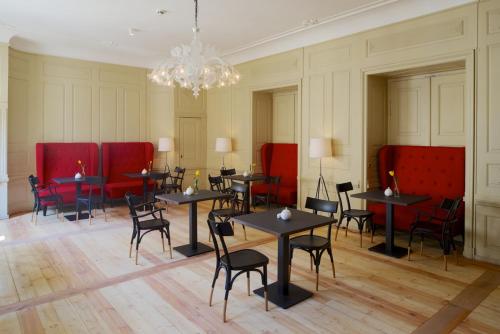 a room with tables and chairs and a chandelier at Hotel Fregehaus in Leipzig