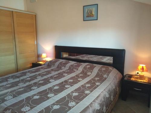 - une chambre avec un lit et deux lampes sur les tables dans l'établissement Apartments Popović, à Funtana