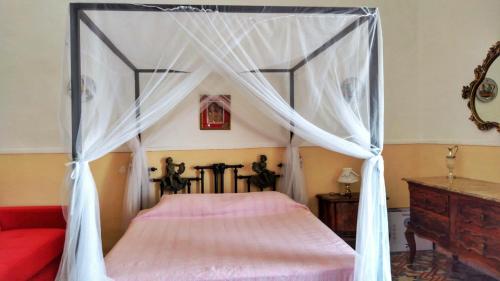 sypialnia z łóżkiem z baldachimem i czerwoną kanapą w obiekcie CERASELLA -vista mare- w mieście Vietri sul Mare