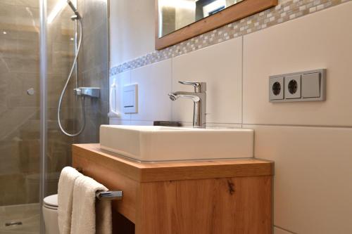 a bathroom with a sink and a shower at Landhaus Thaler in Mittelberg