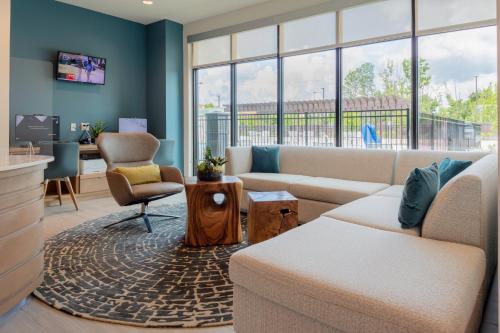 a living room with a couch and chairs and a desk at EVEN Hotels - Shenandoah - The Woodlands by IHG in The Woodlands