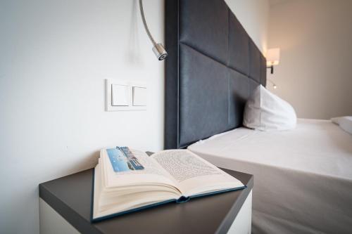 an open book on a table next to a bed at Marina Martinshafen in Sassnitz